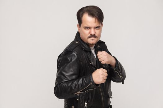 Dangerous boxer. Looking at camera with anger face. Studio shot, gray background