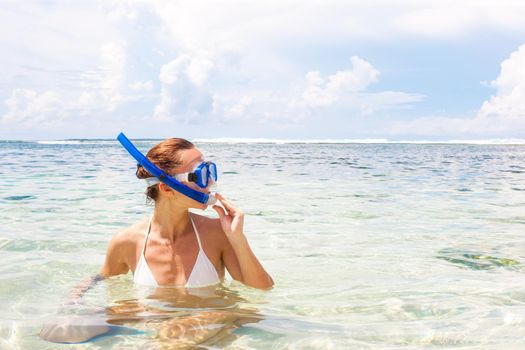 Happy woman on the beach with a diving mask. Bali, Indonesia. Stock image.