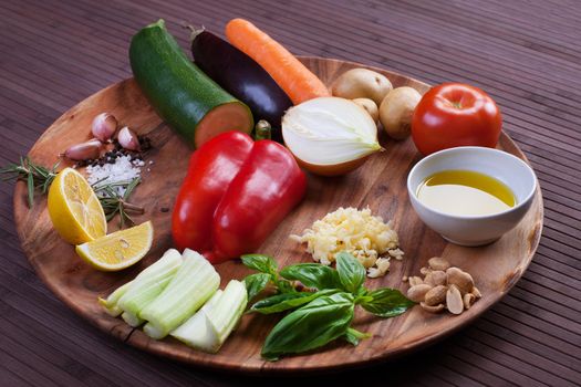 vegetables for soup with pesto sauce and basil on a wooden plate. Stock image.