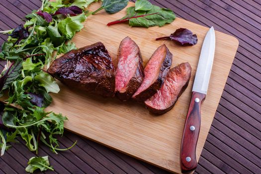 Beef grilled with blood on the kitchen blackboard. Stock image.