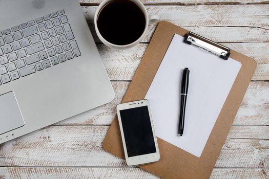 Cup of coffee and laptop on wooden table. Stock image.