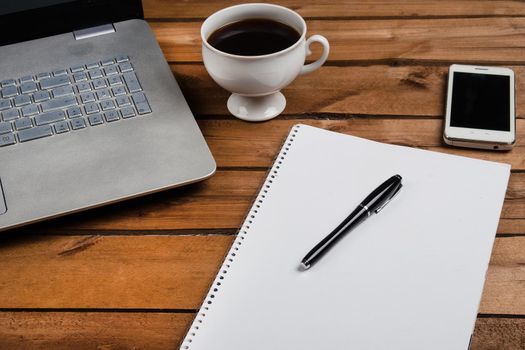 Cup of coffee and laptop on wooden table. Stock image.