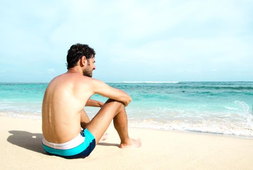 The man enjoys the view of the ocean on a sunny beach. Stock image