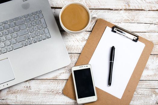 Cup of coffee and laptop on wooden table. Stock image.