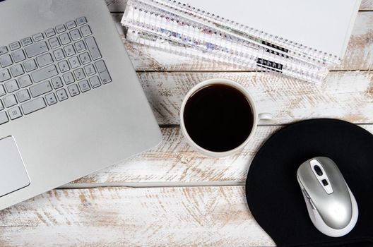 Cup of coffee and laptop on wooden table. Stock image.