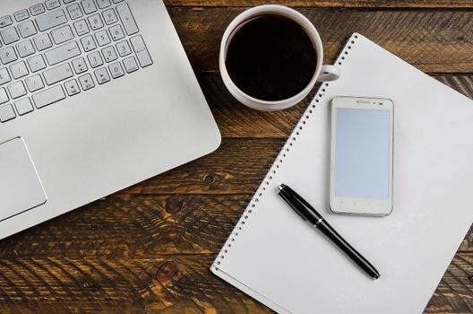 Cup of coffee and laptop on wooden table. Stock image.