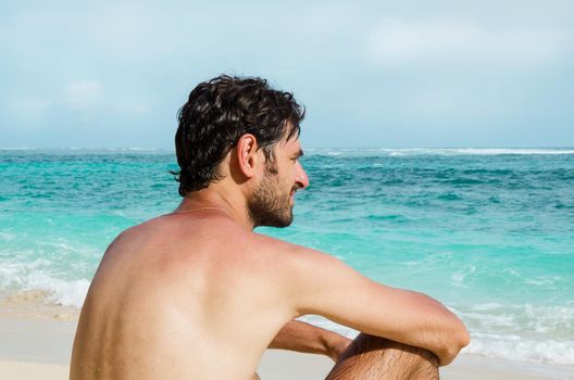 The man enjoys the view of the ocean on a sunny beach. Stock image