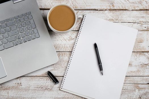 Cup of coffee and laptop on wooden office table. Stock image.