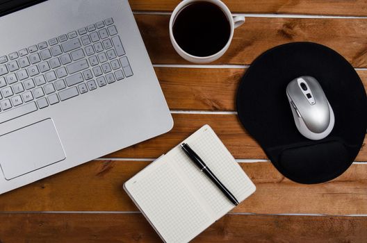 Cup of coffee and laptop on wooden table. Stock image.