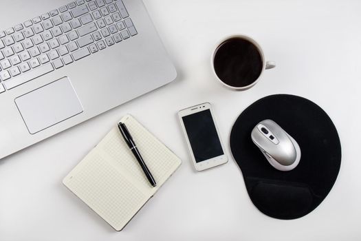 Cup of coffee and laptop on white table. Stock image.