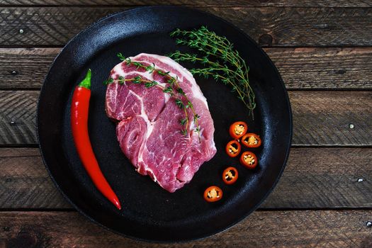 Cooking a steak in a frying pan with thyme and chilli. Stock image.