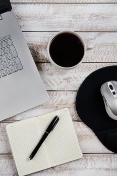 Cup of coffee and laptop on wooden table. Stock image.