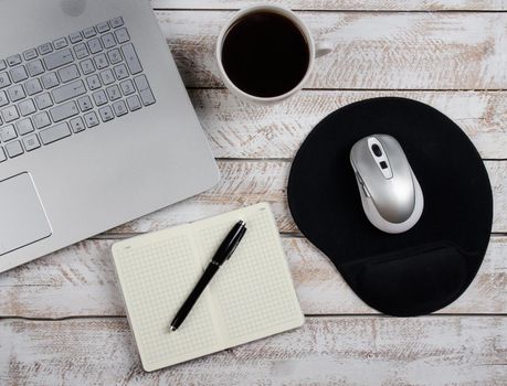 Cup of coffee and laptop on wooden table. Stock image.