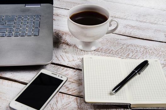 Cup of coffee and laptop on wooden table. Stock image.