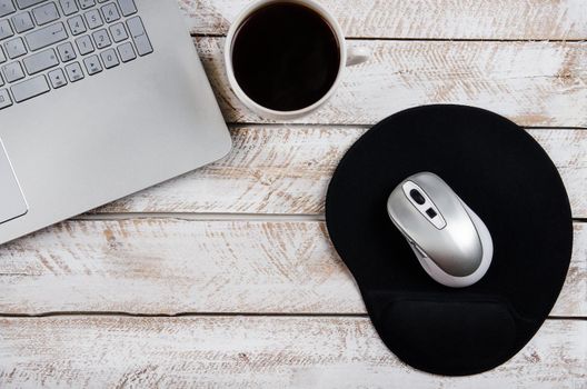 Cup of coffee and laptop on wooden table. Stock image.