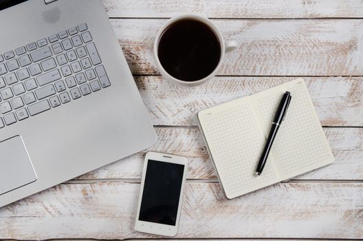 Cup of coffee and laptop on wooden table. Stock image.