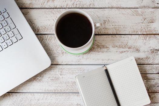 Cup of coffee and laptop on wooden table. Stock image.