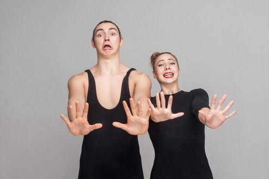 Fear! Couple afraidand have a scared and stressed look. Studio shot, isolated on gray background