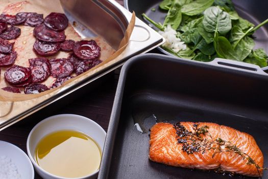 Salmon fillet with baked beetroot on a black plate. Stock image.