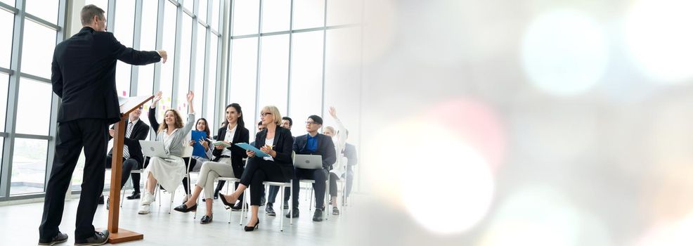 Group of business people meeting in a seminar conference widen view . Audience listening to instructor in employee education training session . Office worker community summit forum with speaker .