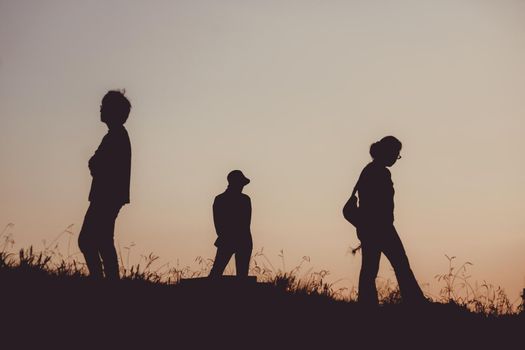 Silhouette of people sitting on the hill at dusk. Shooting Location: Mitaka City, Tokyo
