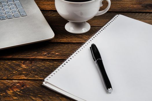 Cup of coffee and laptop on wooden table. Stock image.