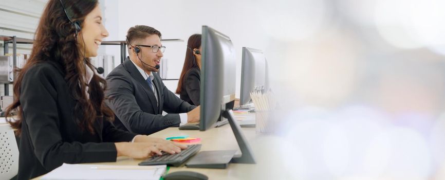 Business people wearing headset working in office to support remote customer or colleague. Call center, telemarketing, customer support agent provide service in broaden view .