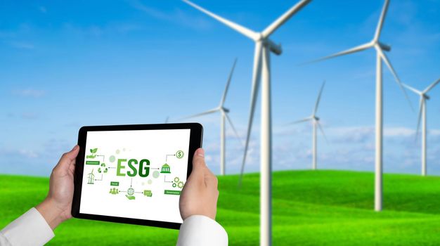 Green business transformation for environment saving and ESG business concept. Businessman using tablet to set corporate goal toward environmental friendly management and alternative clean energy use.