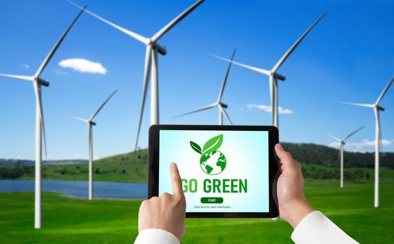 Green business transformation for environment saving and ESG business concept. Businessman using tablet to set corporate goal toward environmental friendly management and alternative clean energy use.