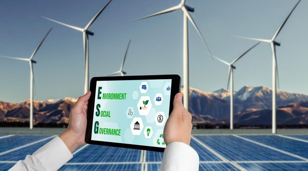 Green business transformation for environment saving and ESG business concept. Businessman using tablet to set corporate goal toward environmental friendly management and alternative clean energy use.