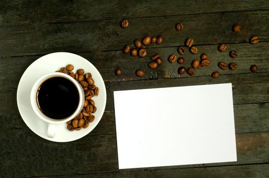 a cup of coffee with coffee beans on wooden table.Flatlay, mock up