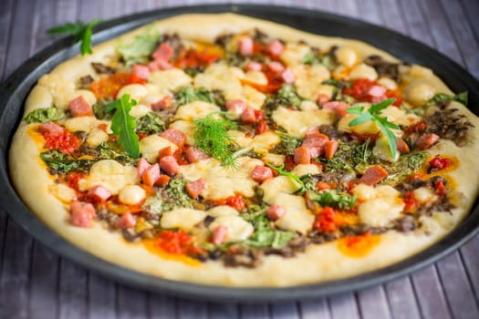 cooked pizza with mushrooms and vegetables with cheese and spices, close-up.