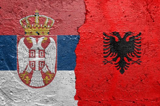 Serbia and Albania flags  - Cracked concrete wall painted with a Serbian flag on the left and a Albanian flag on the right