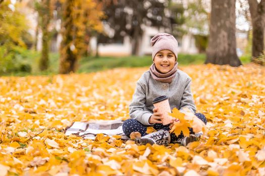 Kids play in autumn park. Children throwing yellow leaves. Child girl with maple leaf. Fall foliage. Family outdoor fun in autumn. Toddler or preschooler in fall.