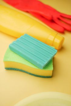 sponge , rubber gloves and colorful plate on pink .
