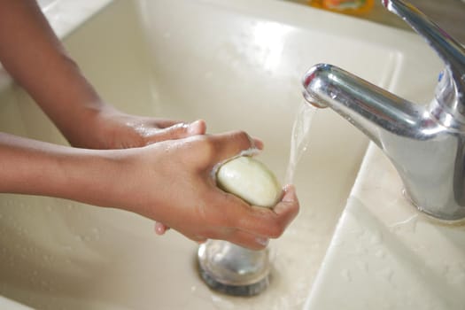 young man washing hands with soap warm water.