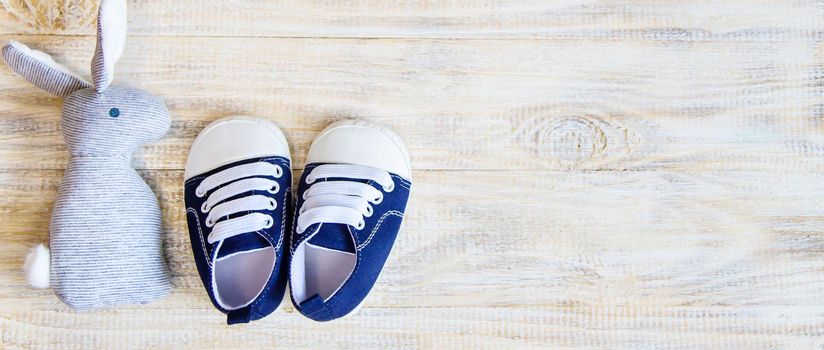 Baby booties and accessories on a light background. Selective focus.