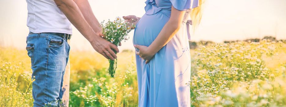 pregnant woman and man gives flowers. Selective focus. nature.