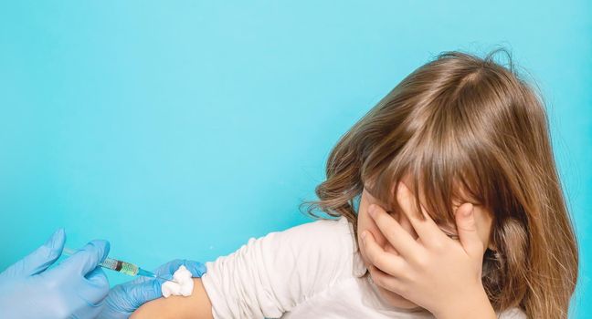 The child is injected into the arm. Selective focus.