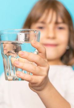 Child girl drinks water from a glass. Selective focus.