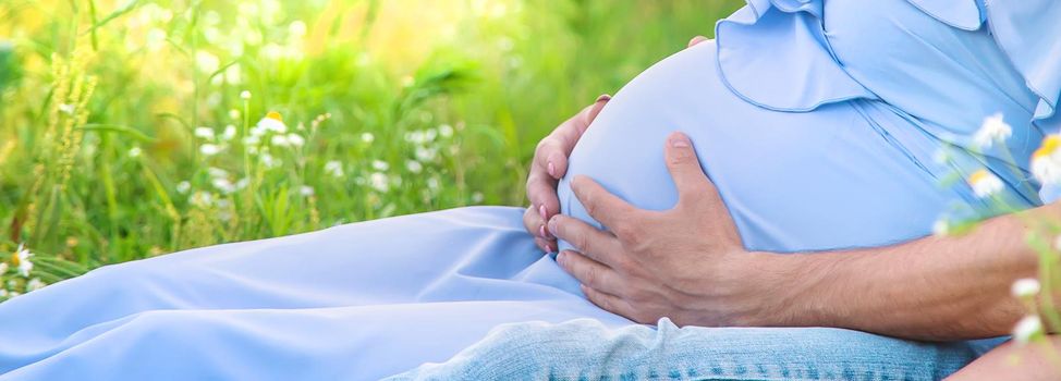 man hugs belly of a pregnant woman on nature. Selective focus. nature.