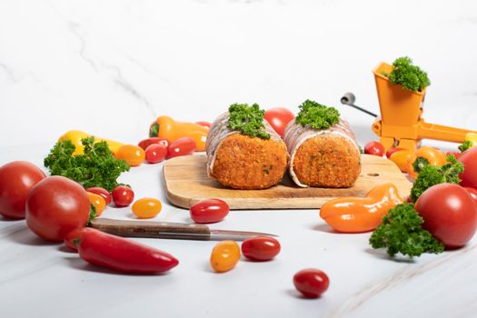 minced meat sausages in bacon with green parsley and fresh vegetables, cherry tomatoes, bell peppers, colorful food . High quality photo