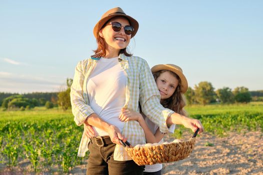 Agriculture, farming organic eco products. Women mother and daughter with basket of eggs, lifestyle, nature, garden, sunset, country side background