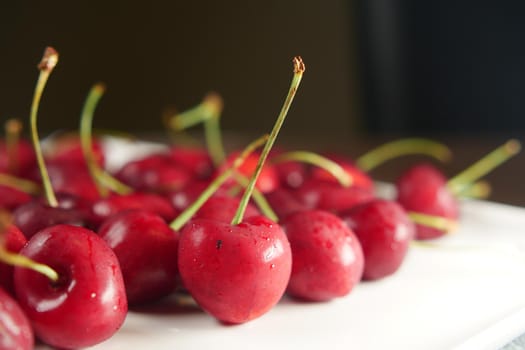ripe fresh cherry on a white tray .