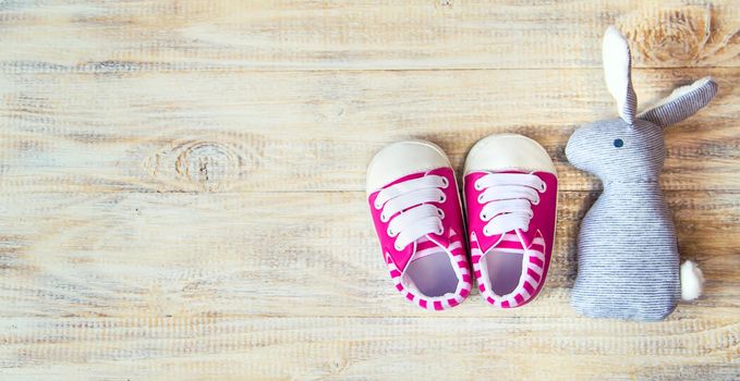 Baby booties and accessories on a light background. Selective focus.