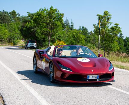 URBINO, ITALY - JUN 16 - 2022 : FERRARI TRIBUTE Ferrari F8 Spider IN an old racing car in rally Mille Miglia 2022