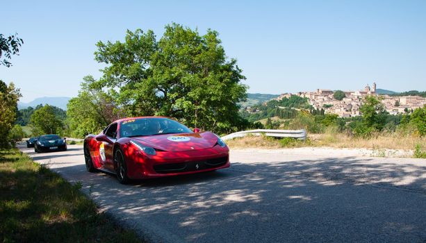 URBINO, ITALY - JUN 16 - 2022 : LAD SCAPE URBINO FERRARI TRIBUTE Ferrari 812 Superfast IN an old racing car in rally Mille Miglia 2022