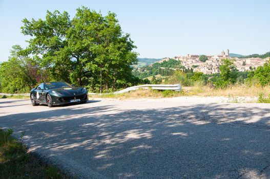 URBINO, ITALY - JUN 16 - 2022 : LAD SCAPE URBINO FERRARI TRIBUTE Ferrari 812 Superfast IN an old racing car in rally Mille Miglia 2022