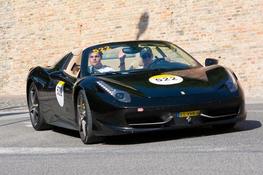 URBINO, ITALY - JUN 16 - 2022 : FERRARI TRIBUTE Ferrari 458 Spider IN an old racing car in rally Mille Miglia 2022