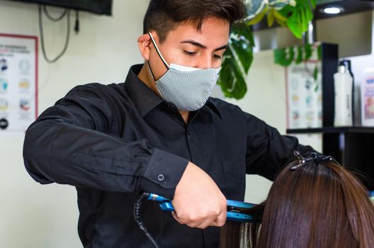 Young man and woman hairdressers in beauty salon